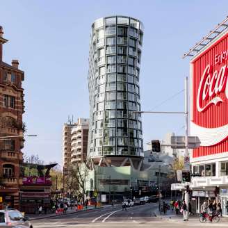 An hour glass shaped apartment building in the middle a busy urban centre